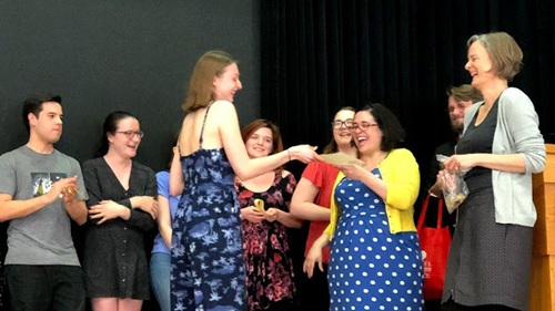 People gathered on a stage talk and laugh.
