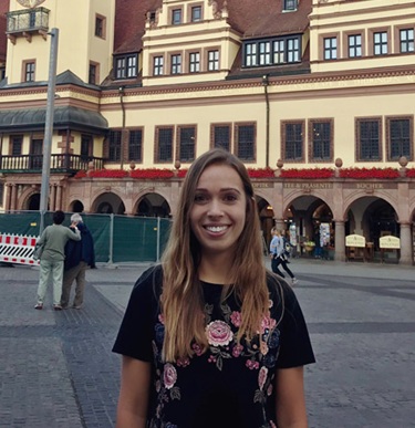 Rebecca Toto stands in front of a building in Leipzig.