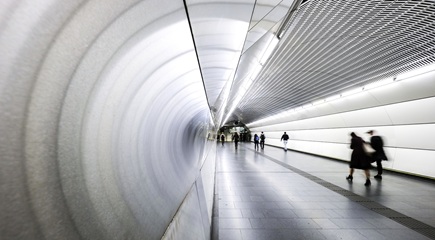 An underground pedestrian tunnel lit up with bright lights.