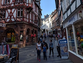 People walking a street with shops in Germany.