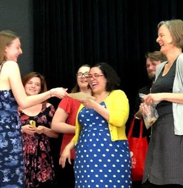 People gathered on a stage talking and laughing.